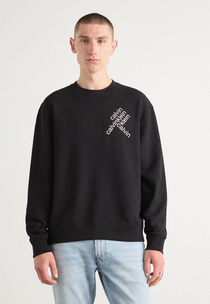 Sweatshirt negru din bumbac cu guler rotund, având text alb diagonal "calvin klein" pe pieptul stâng. Croi casual și mâneci lungi.