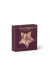 Jedwabna gumka w oknie w kształcie gwiazdy, w kolorze mauve, z złotym napisem na ciemnofioletowym tle i akcentami gwiazdek.