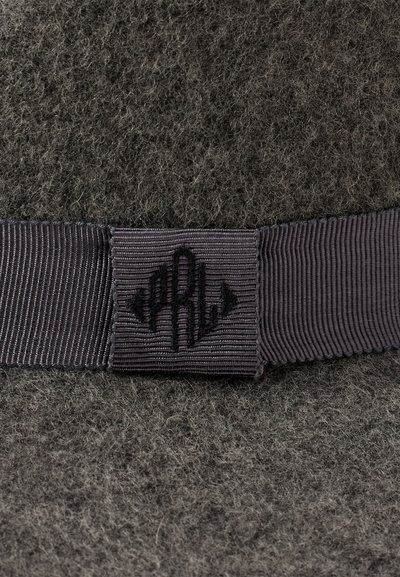 Pălărie gri din fetru cu o suprafață texturată, având o bandă dintr-un gri închis cu dungi verticale și un emblem subtile.