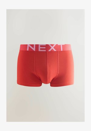 Boxer-briefs en coton rouge avec une ceinture élastique rose arborant le mot "NEXT". Le design est simple avec des détails de couture et une coupe ajustée.