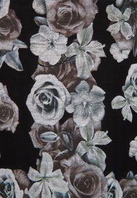 Černá tkanina s květinovým vzorem, na kterém jsou růže v odstínech šedé a bílé, spolu se světlými květinami a zelení.