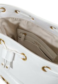 Borsa bianca con finitura lucida, dotata di minuteria dorata, una tasca interna con chiusura a zip e una morbida fodera beige.