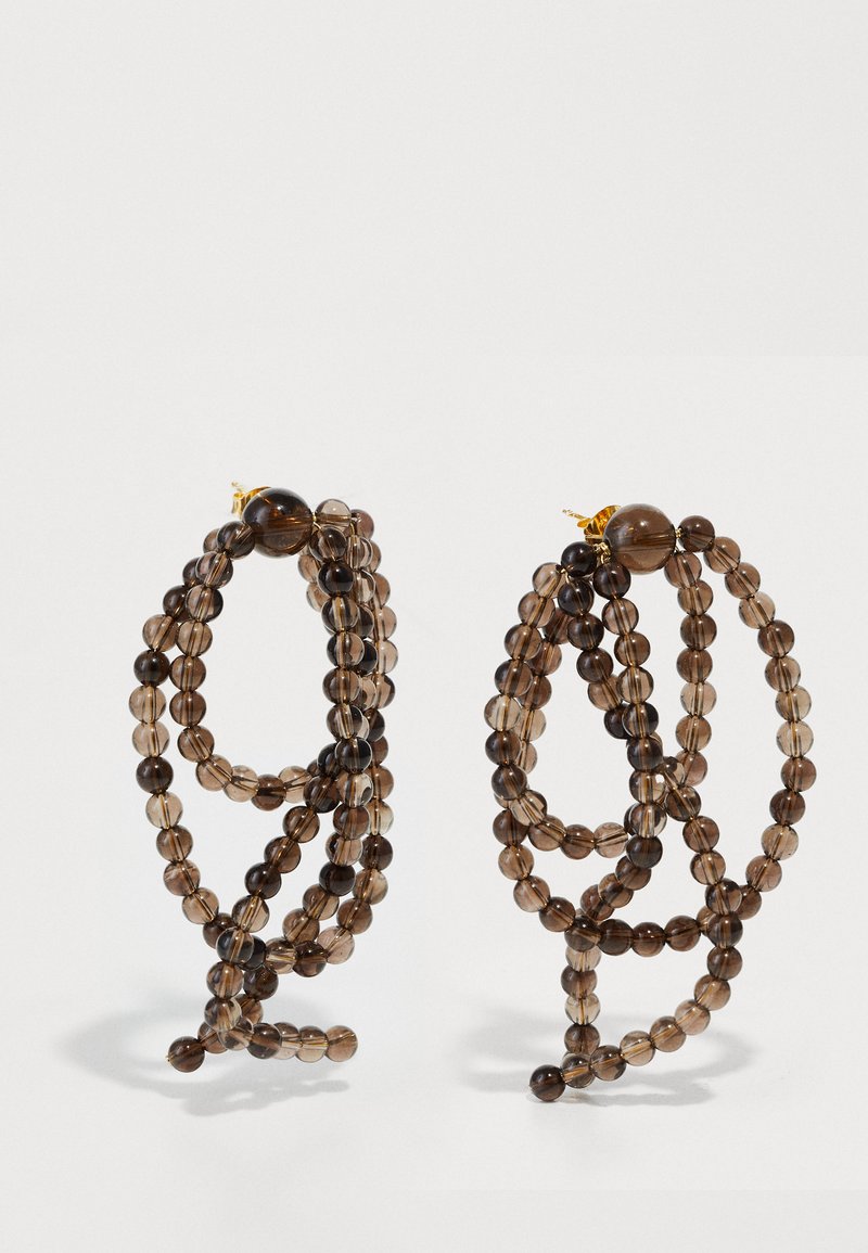 Σκουφάτα σκουλαρίκια με καπνίσμενους καφέ και διαφανείς χάντρες, ακανόνιστο σχέδιο σπείρας και αξεσουάρ σε χρυσό τόνο.