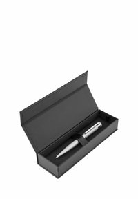 Stylo en métal avec une finition argentée striée dans une boîte rectangulaire noire avec fermeture magnétique et une sangle en tissu pour maintenir le stylo en place.