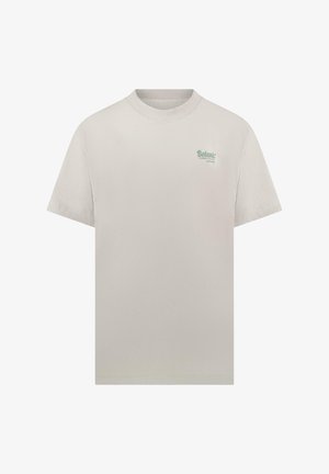 Effen lichtbeige T-shirt met korte mouwen, ronde hals en een klein groen "Botanic" tekstlogo op de linkerborst.