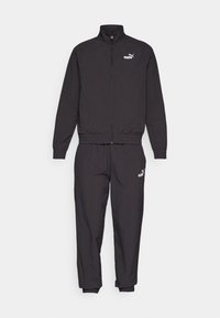 Sort træningsdragt med en lynlåsjakke, der har en stående krave, og bukser med elastisk talje. Fremstillet af letvægtsmateriale med PUMA-logo detaljer.