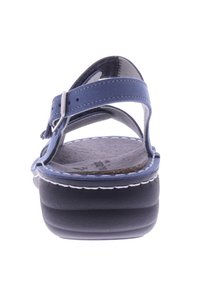 Blaue Leder-Sandale mit verstellbaren Riemen, strukturiertem Fußbett, dicker schwarzer Sohle, weißen Nähten und offenem Design hinten.