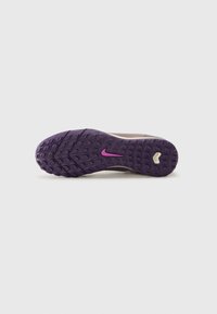 Semelle de chaussure de sport violette avec un caoutchouc texturé et un motif de semelle multi-directionnel. Accents roses remarquables sur la marque.