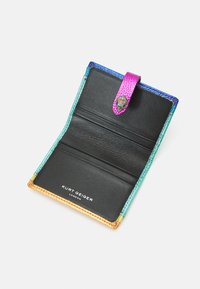 Zwarte leren portemonnee met kleurrijke gestikte randen. Beschikt over een paarse band met een decoratieve sluiting en compartimenten voor kaarten.