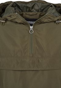 Veste vert olive avec une fermeture éclair avant demi-longueur, un curseur de zip métallique rond et des cordons de capuche réglables avec arrêts métalliques.