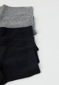 Zestaw trzech skarpetek: jedna jasnoszara na górze, dwie ciemnoniebieskie na dole. Dziane tekstury, ściągacze oraz miękki materiał.