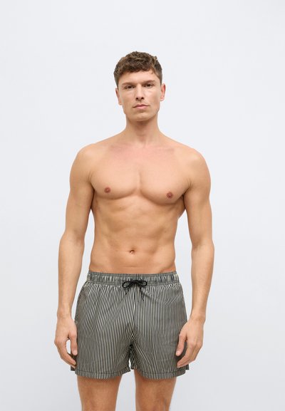 Μαύρα και λευκά ριγέ μαγιό σορτς με ελαστική μέση και κορδόνι. Ελαφρύ υλικό, μεσαίο μήκος. Χωρίς τσέπες.
