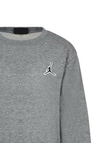 Felpa grigia realizzata in un misto cotone, con collo rotondo e logo Jumpman ricamato in nero sul lato sinistro del petto. Texture liscia, maniche lunghe.