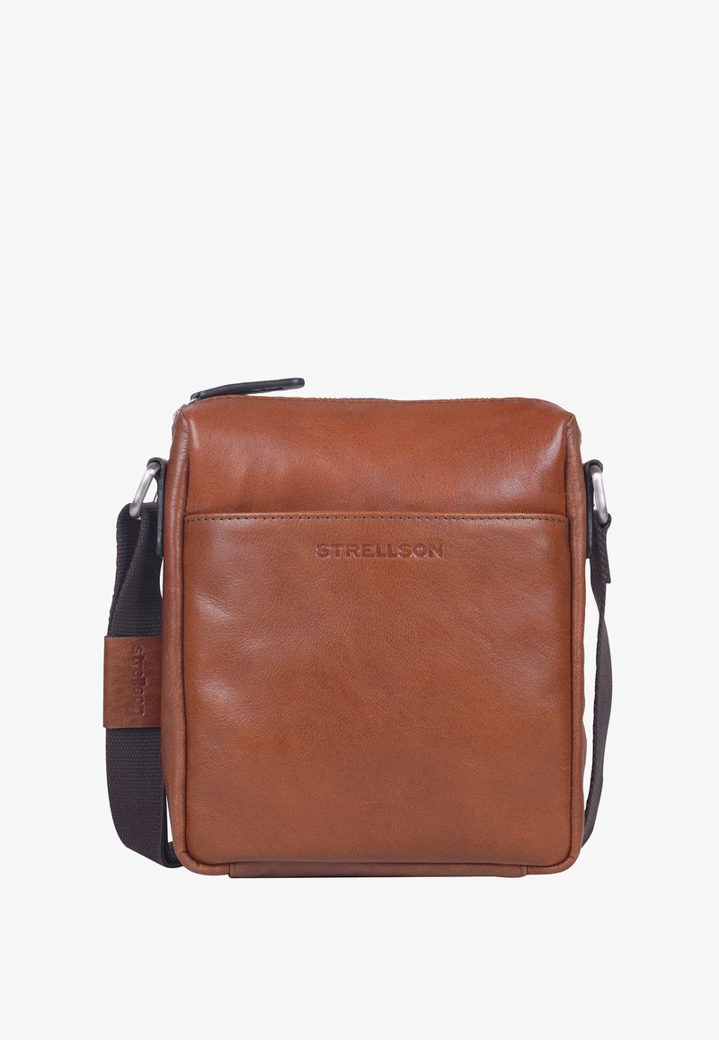 Brązowa skórzana torba o gładkiej fakturze, z suwakowym zapięciem i regulowanym paskiem na ramię. Posiada przednią kieszeń oraz wytłoczone logo.