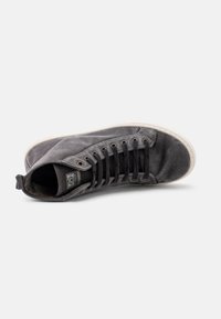 Zapatilla alta gris de lona, con una superficie texturizada, puntera redonda, suela de goma blanca y ojales de metal para los cordones.
