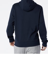 Felpa blu navy con cappuccio regolabile e coulisse, polsini e orlo a costine. Tessuto morbido, texture liscia e design minimalista.