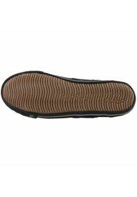 Black shoe sole with wavy texture and light brown rubber. Features a smooth edge, a small logo, and grooves for traction.