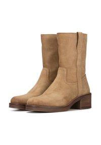 Botas de tobillo de ante marrón con tacón apilado, caña recta, lengüetas en los laterales y detalles de costura sencillos.