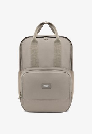 Zaino in tessuto beige con manici superiori rinforzati, tasca frontale con zip e dettagli di logo discreti. Texture liscia, design moderno, forma rettangolare.