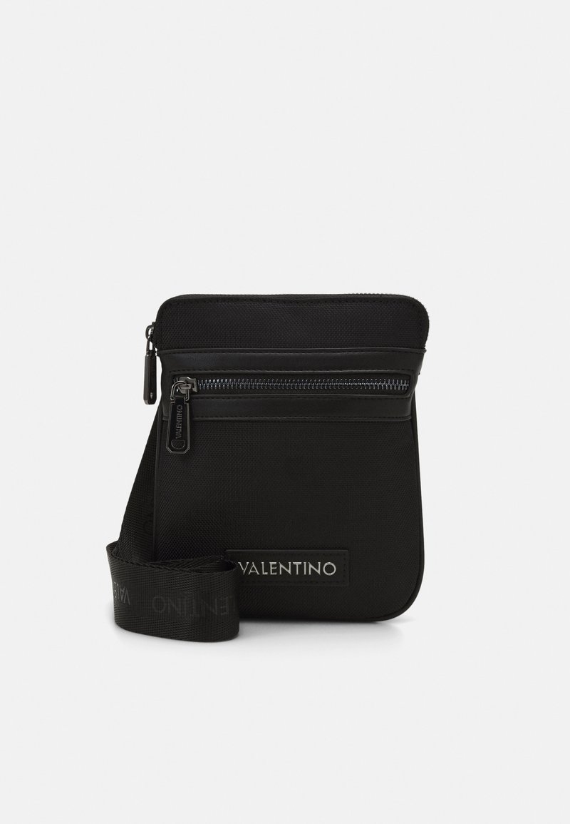 Borsa a tracolla nera realizzata in nylon texturizzato, con una tasca frontale con zip e una tracolla con logo "VALENTINO" in un motivo ripetuto.