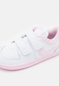 Białe skórzane sneakersy z różowymi akcentami. Posiadają podwójne zapięcia na rzepy, perforowaną część palcową oraz zakrzywiony boczny design. Wyściółka tekstylna.