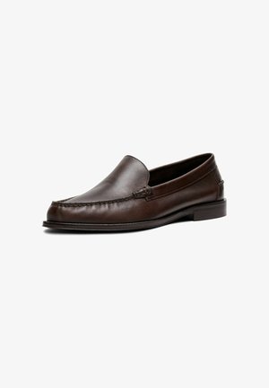 Mocassin homme en cuir marron foncé à enfiler avec petit talon et détails cousus le long de l’avant et des côtés sur fond blanc.