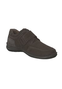 Zapato marrón oscuro con una parte superior texturizada, cierre de tiras de Velcro y costuras en contraste. Punta redondeada y suela de goma acolchada.