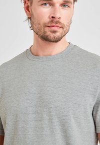 Light gray short-sleeve t-shirt made of soft fabric with a subtle texture and a classic crew neckline.