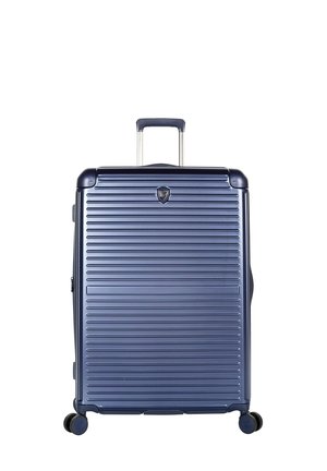 Grande valise rigide bleu marine avec des rainures horizontales, une poignée rétractable et quatre roulettes pivotantes.