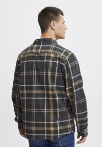Geruite flanellen shirt in de kleuren donkergroen, beige en lavendel; lange mouwen, knoopmanchetten en een klassieke kraag.