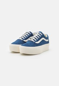 Sneakers in denim blu con lacci bianchi, caratterizzati da una striscia laterale bianca e una suola spessa di gomma color crema. Texture liscia, design low-top.