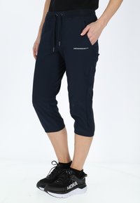 Pantaloni cropped navy realizzati in materiale morbido e elasticizzato. Presentano una vita elastica con cordino e tasche laterali. Logo stampato sul davanti.