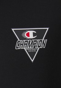 Felpa nera con logo triangolare bianco, rosso e nero. Il testo include "CHAMPION" e "ATHLETICWEAR 1992."