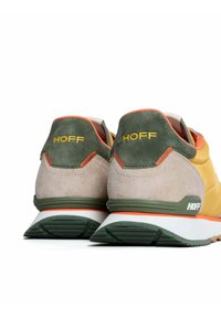 Schoenen met gele, grijze en groene suede, met een opvallend "HOFF" logo. Het ontwerp bevat een gestructureerde hiel en contrasterende accenten.