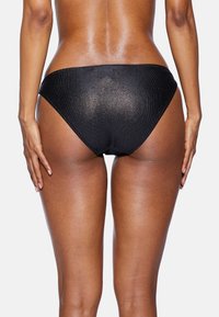 Czarny bikini dolny z prążkowaną fakturą, o średnim stanie, gładkiej powierzchni i minimalnym wycięciu z tyłu. Brak dodatkowych wzorów lub akcentów.