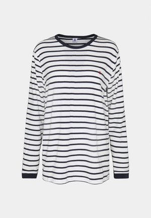 Pitkähihaisen paidan värit ovat valkoinen ja tummansininen raidoitus, pyöreä pääntie, pehmeää puuvillakangasta, jossa on pieni punainen logo rintakehässä.