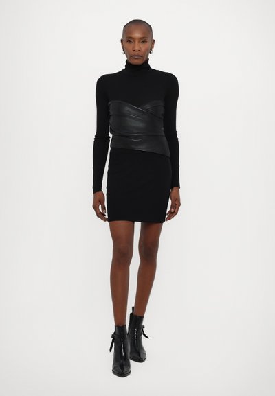 Sort turtleneck kjole med en tætsiddende silhuet, der har en kontrastdetalje i sort læder tværs over brystet og en glat tekstur.
