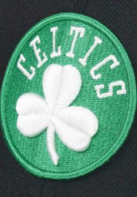 Green circular patch with white embroidered shamrock and the word "CELTICS" in white letters around the top. Black background fabric.