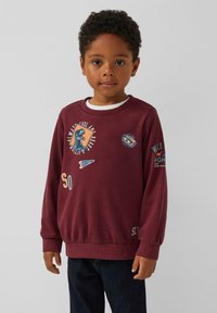 Felpa girocollo bordeaux con stampe grafiche, polsini e orlo a coste. Tessuto in misto cotone, con design di dinosauri e testi.