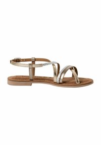 Sandali piatti con un design di cinturini intrecciati metallici oro e argento, un letto in suede marrone e un sottile cinturino alla caviglia con fibbia.
