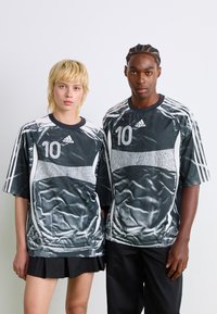 Black and white athletic jerseys with "10" printed on the front, featuring wavy textures, short sleeves, and Adidas logo accents.
