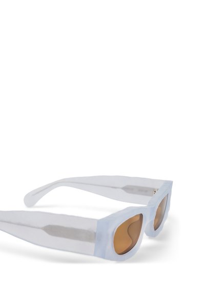 Occhiali da sole in plastica trasparente con ampi telai, dettagli azzurri chiari e lenti marroni, caratterizzati da un design geometrico moderno.