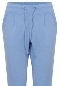Světle modré joggingové kalhoty vyrobené z měkké látky, s elastickým páskem, stahovací šňůrkou a předními sklady pro přidanou strukturu.