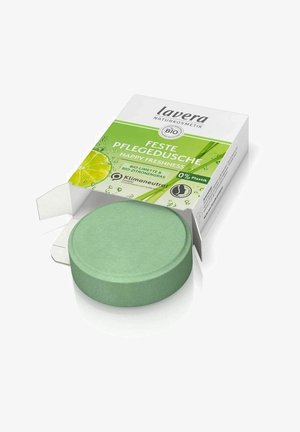 Fester Duschgel in einer runden, grünen Scheibenform, verpackt in einer Box mit grün-weißer Gestaltung und Limettenmotiven sowie umweltfreundlichen Hinweisen.