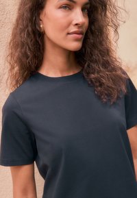 Marineblauw T-shirt met korte mouwen, een klassieke ronde hals, een gladde textuur en subtiele naaddetailering. Geschikt voor casual dragen.