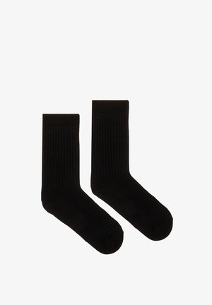 Czarne, prążkowane skarpety o miękkiej fakturze, długości do połowy łydki, ze wzmocnionym palcem i piętą dla trwałości. Prosty i klasyczny wzór.