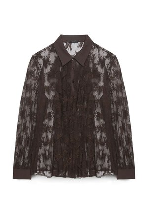 Blusa in pizzo marrone con colletto marrone scuro, caratterizzata da dettagli arricciati sulla parte anteriore e chiusura con bottoni. Tessuto trasparente con motivi floreali.