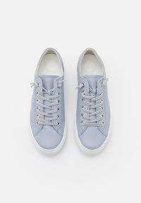 Paio di sneakers in pelle blu chiaro con suole bianche e lacci grigio chiaro coordinati, visti dall'alto su uno sfondo bianco.