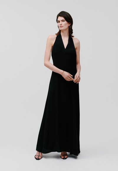 Black halter neck maxi dress with a V-shaped neckline, made from a flowing fabric, featuring a straight silhouette and minimal design details.