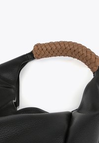 Sac en cuir noir avec une anse en cuir tressé beige. Le sac a une finition texturée et un design à ouverture supérieure.